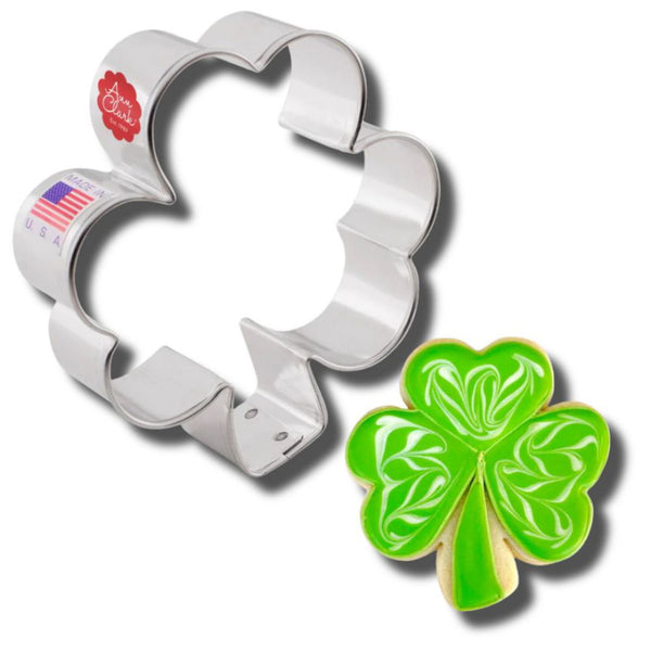 Ann Clark shamrock cookie cutter next to a decorated green clover cookie, perfect for St. Patrick's Day baking.