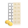 Aluminum mold with decorative pattern and plain surface, next to two yellow pastries on a white background